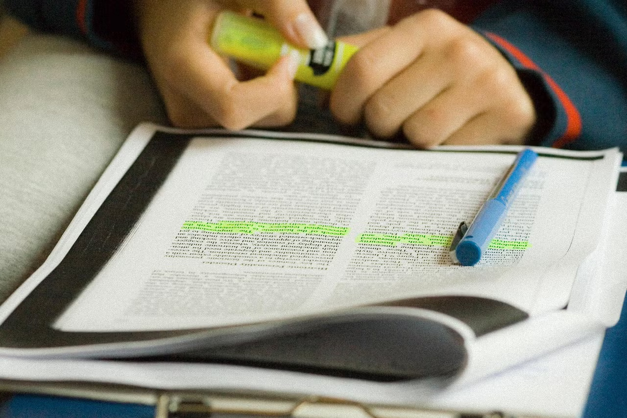 Student reviewing text with a yellow highlighter